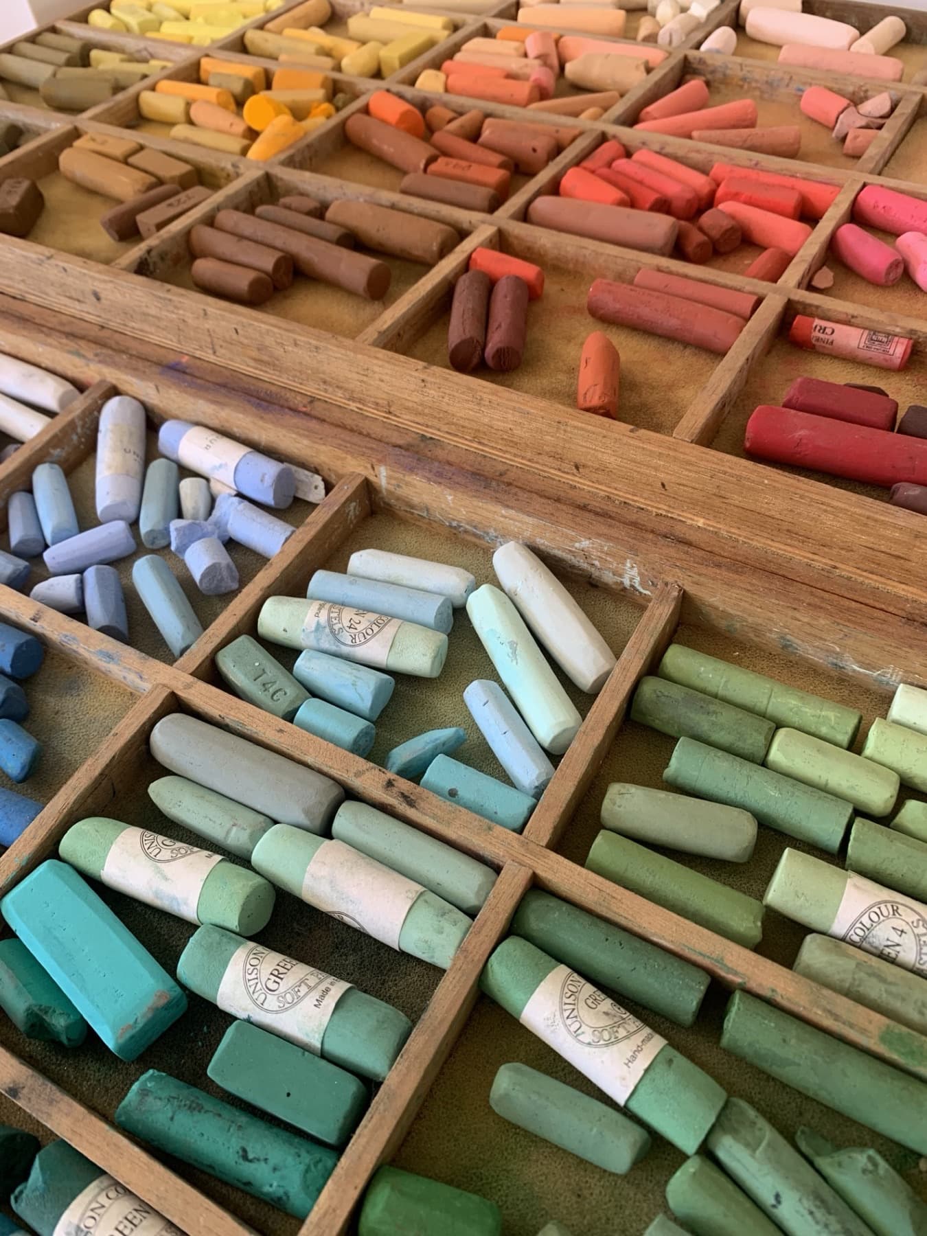 Trays of soft pastels in the studio, sorted by colour
